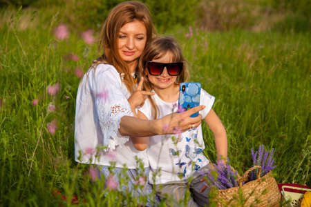 happy family mother and daughter hugging in summer on the nature.