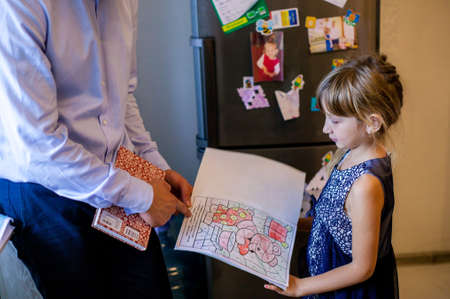 Father Pointing At The Picture Of His Daughter. Happy Father And Little Daughter Enjoying Leisure Time Together.の写真素材
