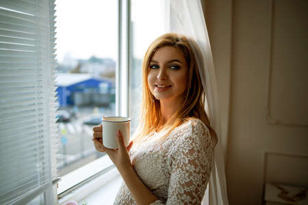 Close Up Of Pregnant Woman With Tea Cup At Windowの写真素材