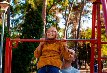 Father and daughter doing sports, doing exercises outdoor in autumn. Healthy Family.の写真素材