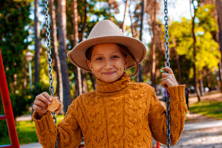 Little girl in a yellow sweater plays in the playgroundの写真素材