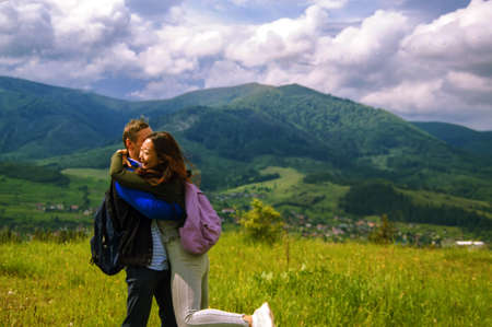portrait of a joyful girl and boy tourists on the top of the mountain admire the beautiful view.の写真素材