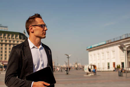 Successful businessman in a suit with glasses in the city