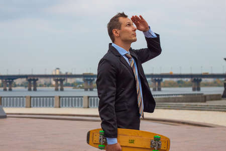 Businessman in business suit in the city with skateboardの写真素材