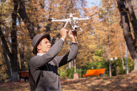 The UAV drone and photographer man hands close-up.drone copter flying with digital camera. Flying camera take a photo and video.の写真素材