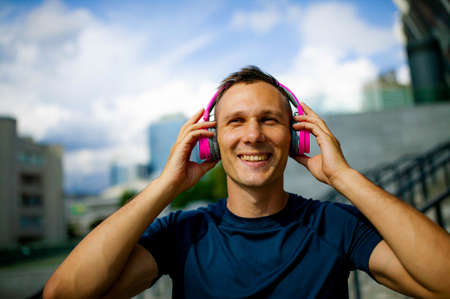 Close up portrait of good-looking sport guy spending time outdoors and expressing positive emotions