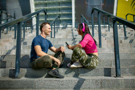 Attractive couple doing exercise and talking in city - fitness healthy lifestyle concept outdoor.の写真素材