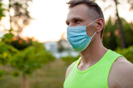 Young man in mask Trying To Do Sport During pandemicの写真素材