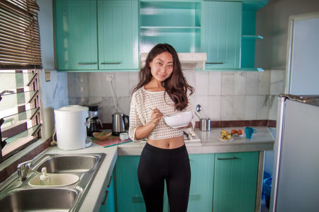 Beautiful happy asian woman cooking at kitchen.の写真素材