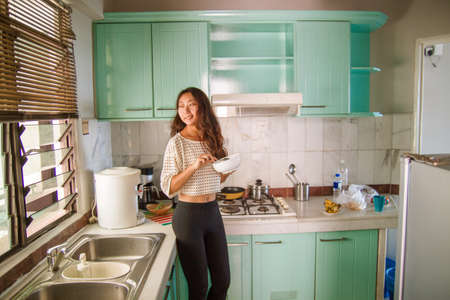 Beautiful happy asian woman cooking at kitchen.の写真素材