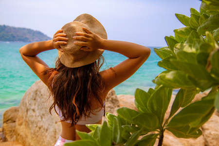Happy smiling asian woman in straw hat on the sea beach.