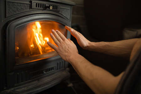 Hands In Front Of The Fire To Keep Warmの写真素材