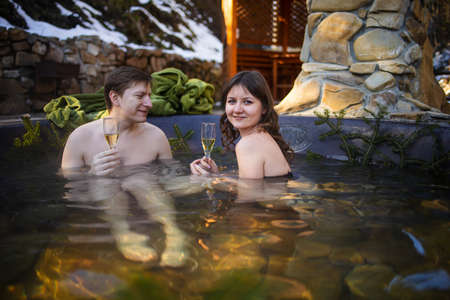 Wellness Spa, Young Couple Relaxing with champagne In Hot Tub  Outdoor. Honeymoon Couple Relaxing Together.の写真素材
