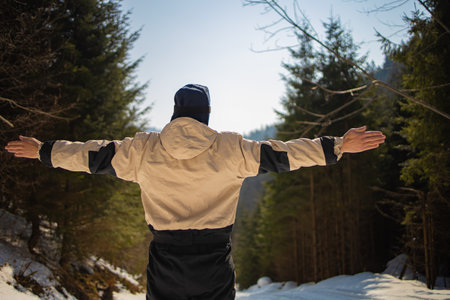 Male Snowboarder In Ski Suit Stands On The Snowy Hillの写真素材