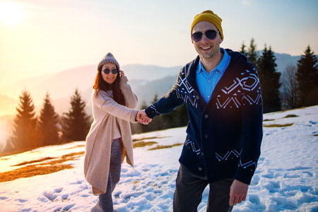 Young Couple Walking Through The Winter Forest Holding Handsの写真素材
