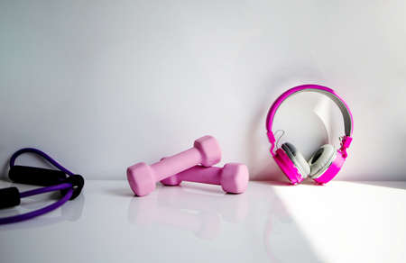 Pink Dumbbells And In-Ear Headphones. Sport And Fitness