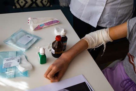 Orthopedist Applying Bandage Onto Patient's Hand In Clinic