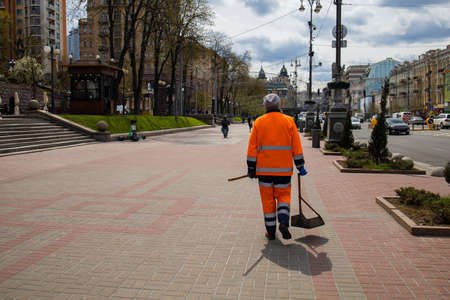 Street Cleaner With A Recognizable Orange Jacket That Cleans The Streetの写真素材