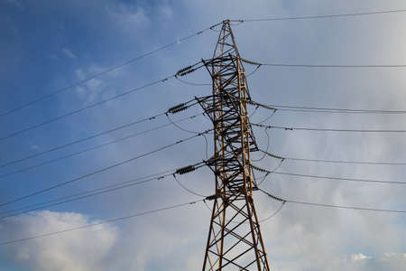 High Voltage Electric Tower Against The Blue Sky. High Steel Power Under Blue Cloudy Sky