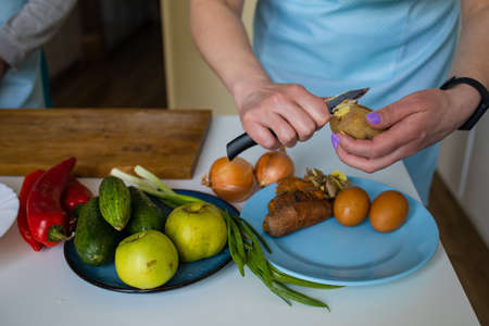 Female Hand Cut Vegetables On Rustic Kitchen Table, Cooking And Vegetarian Concept.