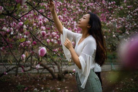 Attractive Asian Woman In Spring Garden With Magnolias. Spring Background. Woman's day