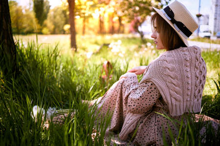 Charming Sensual Young Woman Sitting On Grass In Garden In Spring Park.