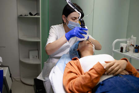 Doctor Cosmetologist Does The Procedure Of Laser Resurfacing Of The Face.の写真素材