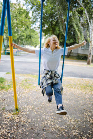 Happy Healthy Teen Girl Wear Casual Cloth Smile Sitting Play Swing In The Park