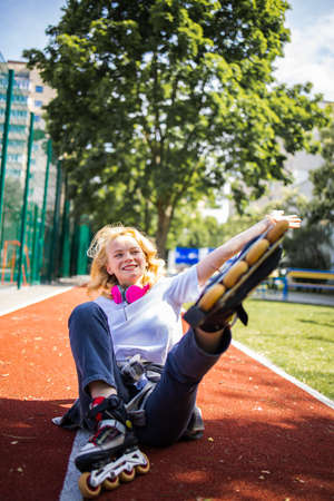 Pretty Teenage Girl Wearing Roller Skaters On The Road In Summe Park.