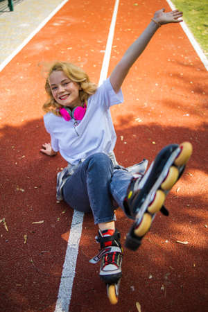 Pretty Teenage Girl Wearing Roller Skaters On The Road In Summe Park.