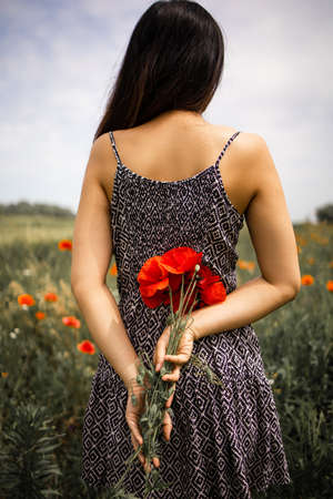 Woman With A Bunch Of Red Poppies In Field.の写真素材