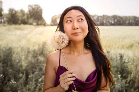 Allergy Free Concept. Asian Woman Blowing Dandelionの写真素材