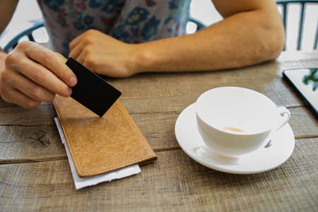 Man With Credit Card Paying For Coffee At Cafe
