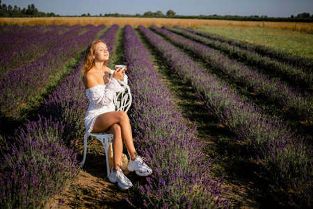 Pretty Blonde Woman Drinking Tea In Lavender Field.の写真素材