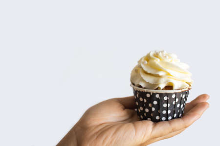 A Female Hand Holds A Cupcake With Creamの写真素材
