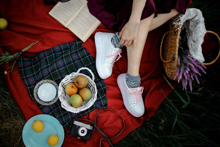 Woman Lying Outdoors At Park With Picnic Basket Eatting Appleの写真素材