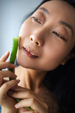 Aloe Vera Takes Care Of My Skin! Beautiful Asian Woman Posing With A Leaf Of Aloeの写真素材