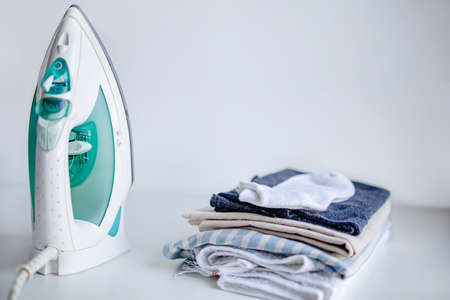 Household laundry ironing. Iron on table on white background, Copy Space.の写真素材