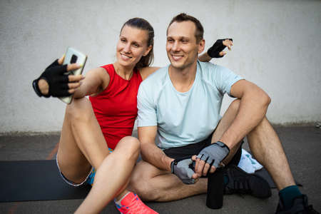 happy Young sports couple making selfie photo on stadiumの写真素材