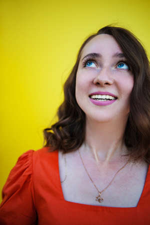 Closeup photo of amazing lady looking up empty space deep thinking creative person isolated yellow color backgroundの写真素材