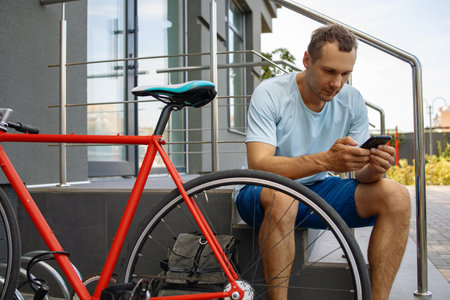 Young Man With A Bike In The City, Using Smartphone