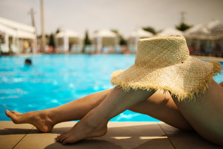 Beautiful slim women legs by the swimming poolの写真素材