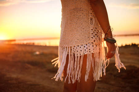 Photo of beautiful boho styled model wearing white and silver bohemian jewelery on the beach in...