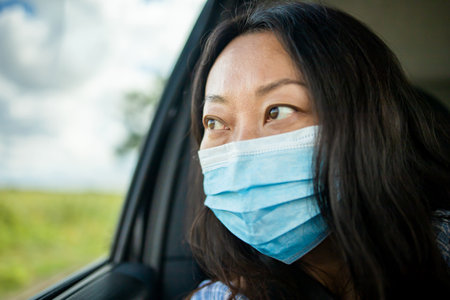 Sad Asian woman commute by taxi and she wear face mask to avoid infectious diseases
