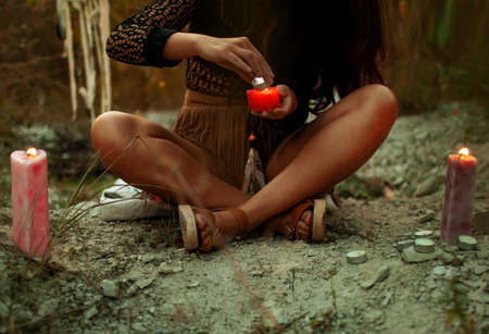 Asian woman with candles deep in the forest. Witchcraft conceptの写真素材
