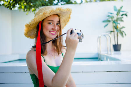 Portrait beautiful young red hair woman relax smile leisure around outdoor swimming pool nearly sea beach ocean for holiday vacationの写真素材