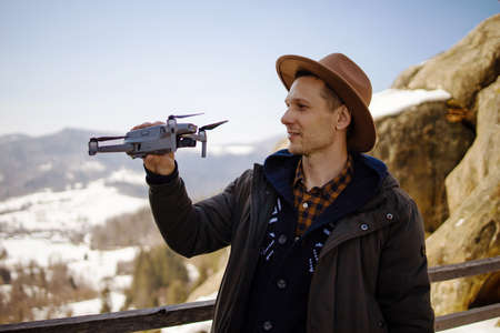 Man hipster controls the flying drones in snowy forest winter. Adventurous winter holidayの写真素材