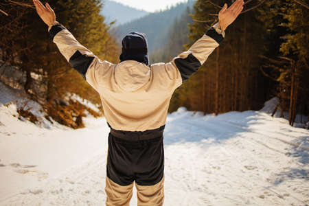 Young man with ski in the snow forest standing on the top of hill.の写真素材