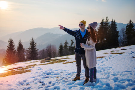 Winter Love Story. Mixed race couple walking in winter forest during a snowfall on holidaysの写真素材