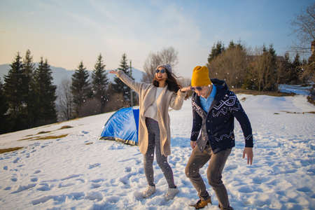 Young mixed race couple having fun on the snow on winter vacationの写真素材